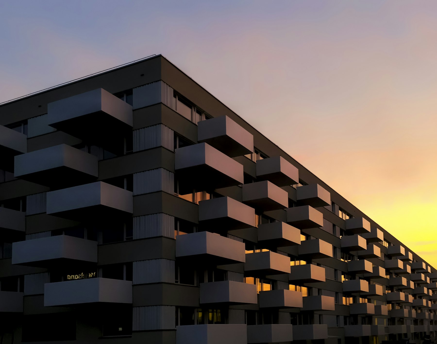 Moderne gevel met warm verlichte vensters in het gouden uur